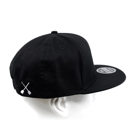 Black snapback cap on head form, showing side panel and white X logo