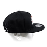 Black snapback cap with side graphic patch and curved brim on head form
