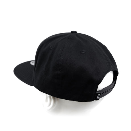 Black snapback cap from back-right angle with adjustable strap panel.