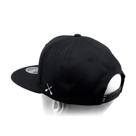 Black baseball cap with white crossbones graphic and adjustable back strap