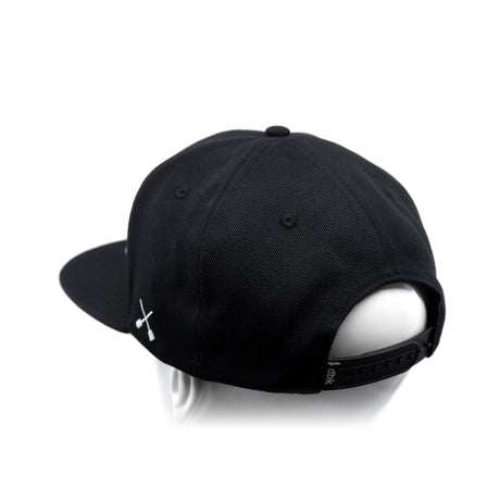 Black baseball cap with white crossbones logo and adjustable back strap detail
