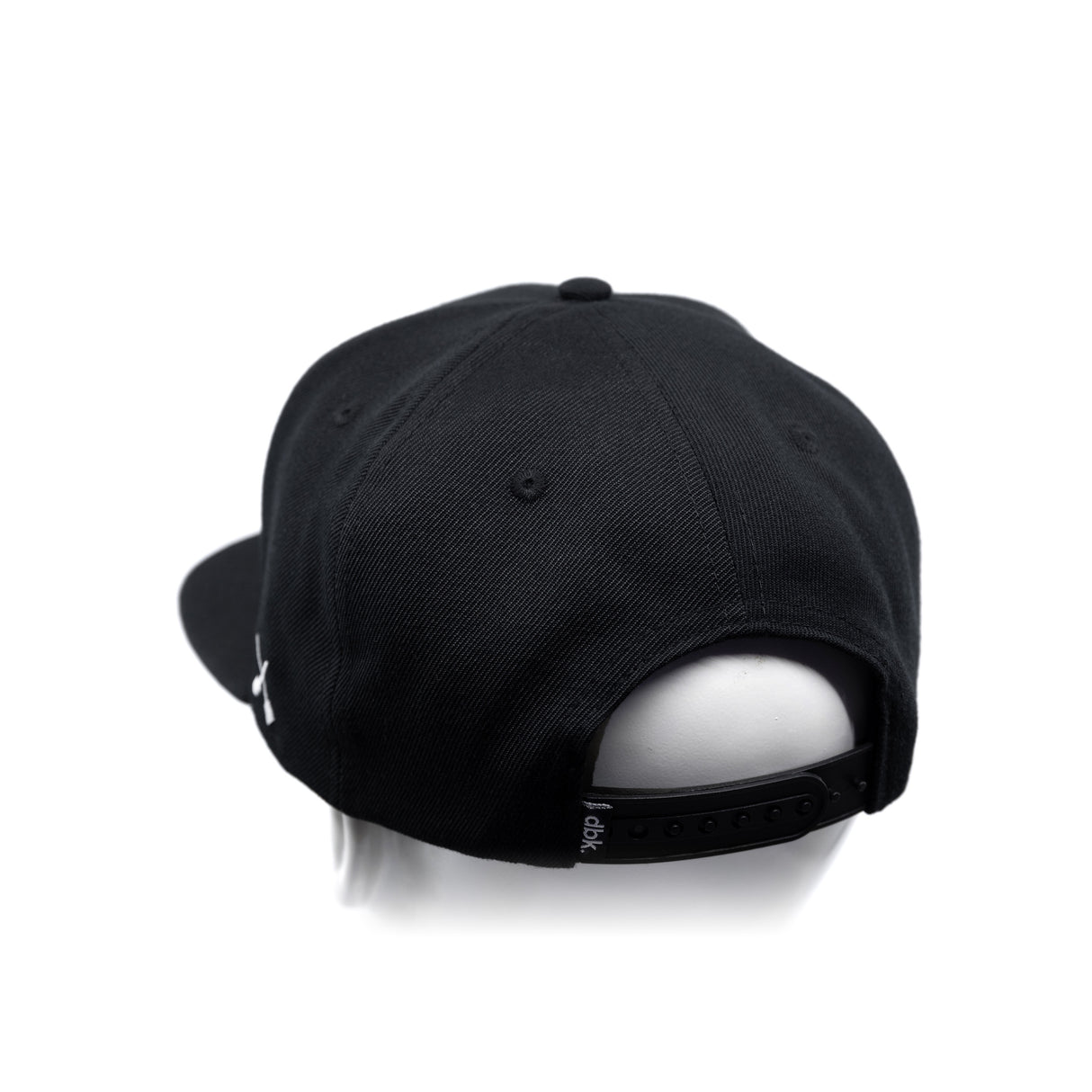 Black baseball cap with adjustable back strap and curved brim, side view
