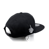 Black snapback cap with curved brim and white hand emblem embroidery