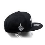 Black snapback cap with curved brim, white hand emblem, and side logo text