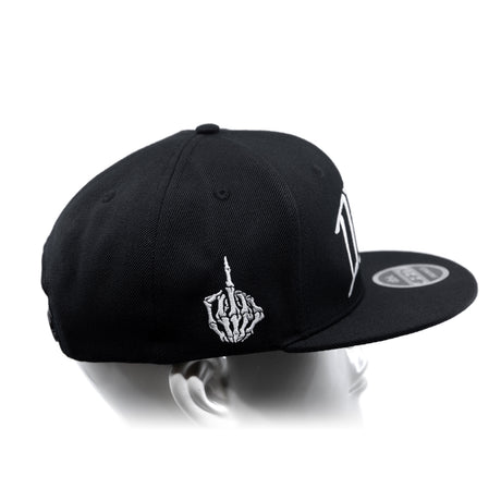 Black snapback cap with curved brim, white hand emblem, and side logo text