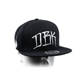 Black snapback cap with large white DBK lettering on front