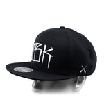 Black baseball cap with partial white 'DBK' lettering and white crossbones on the side