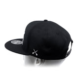 Black baseball cap with white crossbones logo and side panel view