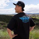 Black T-shirt back view with centered blue DBK logo graphic.