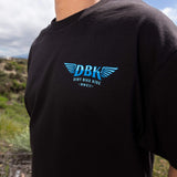 Black T-shirt back print with blue DBK wings logo and tagline text.