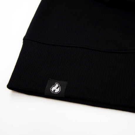 Schwarzer Saum mit Rippbündchen und kleinem Flame-Patch unten am Sweatshirt