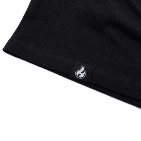 Black T-shirt hem with small flame logo patch