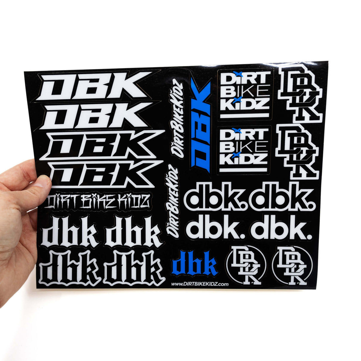 Sticker sheet held in hand with white bike-kidz and dbk logos on black