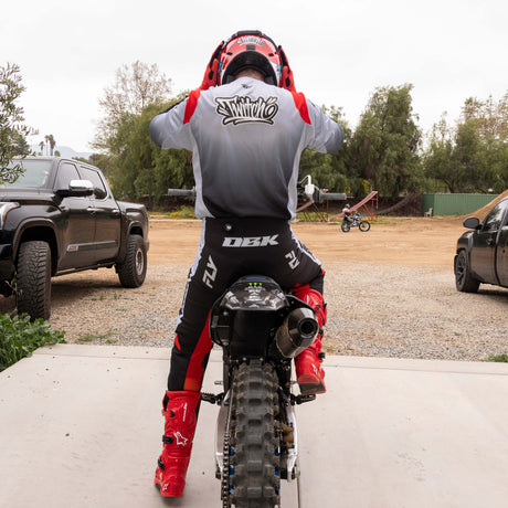 Motocross jersey back view in light gray and black gradient with red shoulders and gray sleeve details