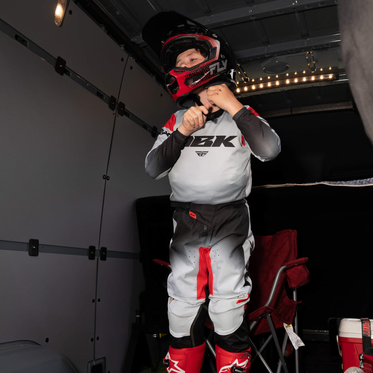 Youth motocross jersey, front view, light gray with red accents and black cuffs and hem