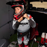 Youth motocross pants, light gray and black with red side inserts and knee patch