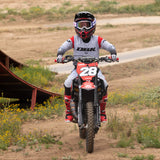 Youth motocross jersey on rider, light gray with red shoulder panels and dark lower gradient