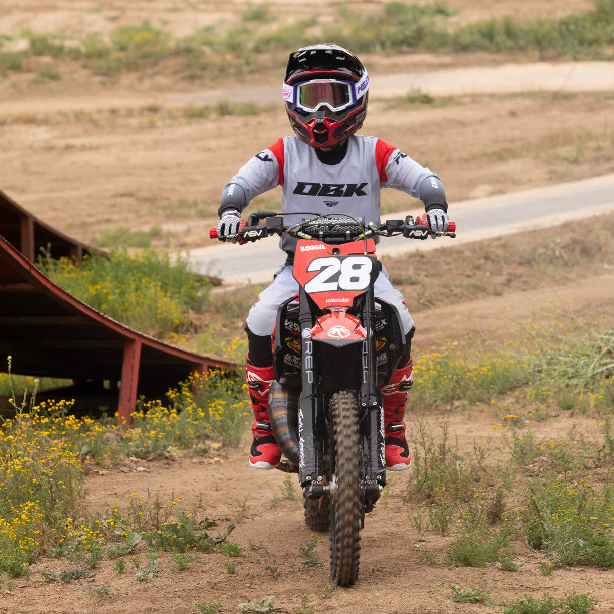 Youth motocross pants on rider, light gray and black with red highlights and panel seams