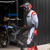Motocross jersey in light gray and black with red shoulder panel, mesh side panels, and sleeve graphics