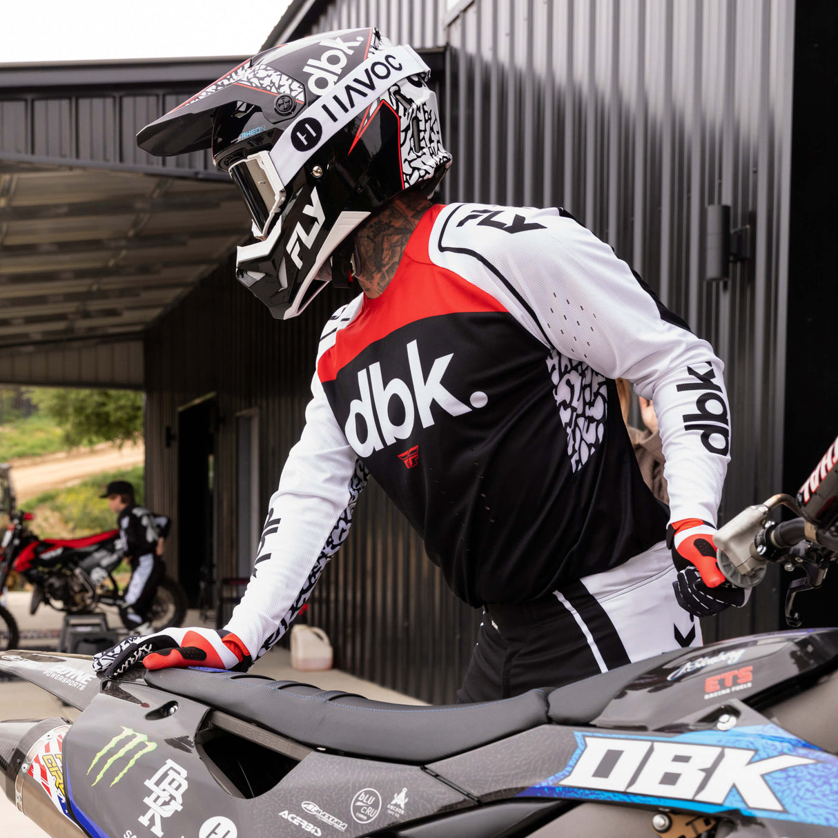 Motorcycle helmet on rider, black with white/red graphics and open visor