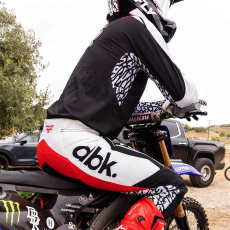 Motorcycle pant, black and white with bold red stripe and patterned side panels