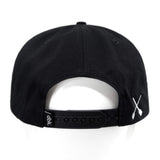 Black snapback hat with side strap and white X detail near the brim.