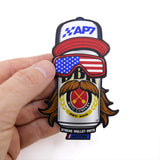 Sticker held in hand, with AP7 cap, American flag goggles, and laurel rider mustache
