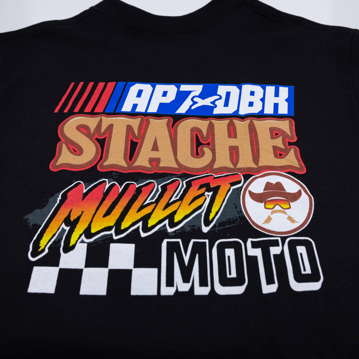 Black Roadhouse AP7 tee chest graphic close-up with APXDBK STACHE MULLET MOTO text