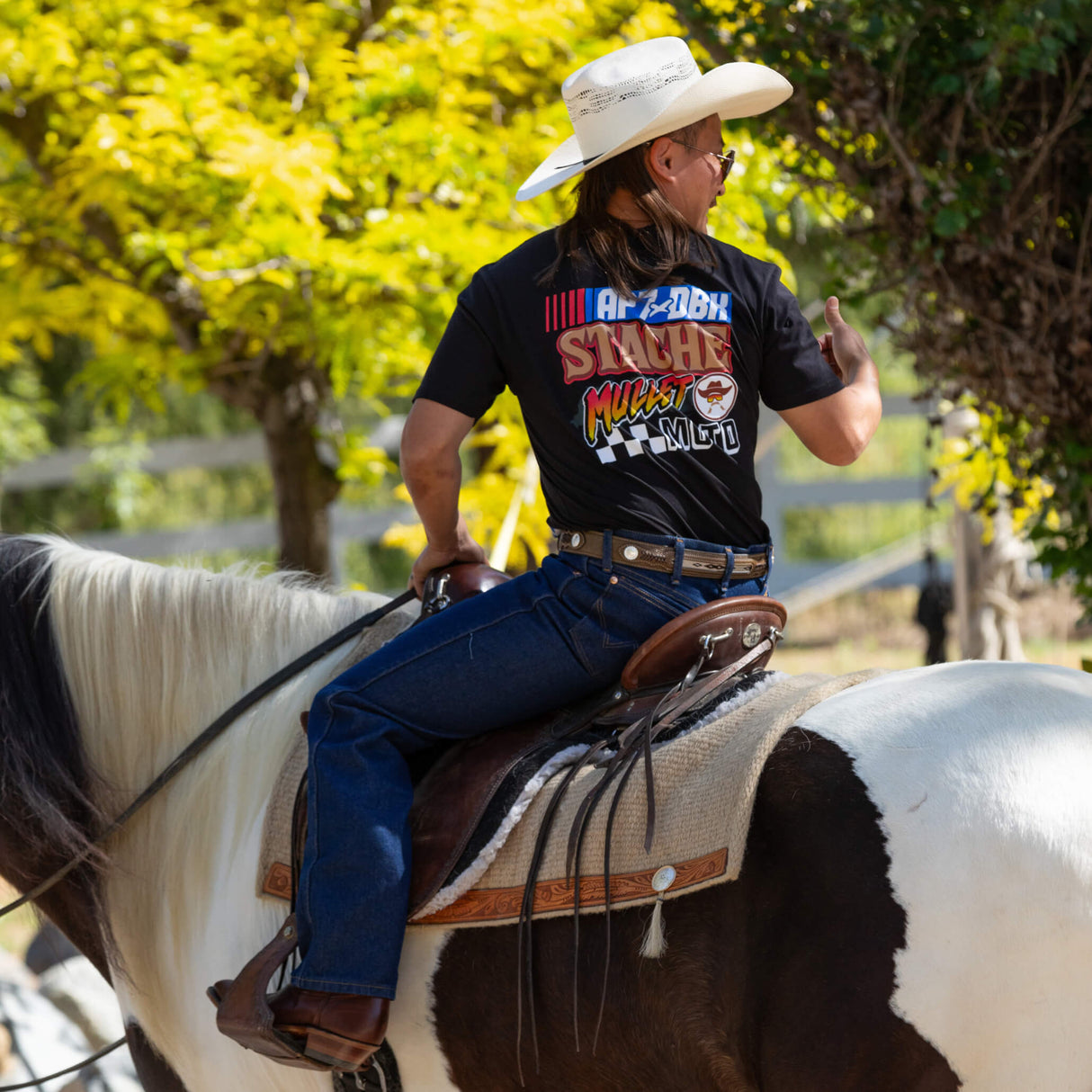 Black Roadhouse AP7 tee worn outdoors, back graphic reads STACHE MULLET MOTO