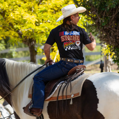 Black Roadhouse AP7 tee worn outdoors, back graphic reads STACHE MULLET MOTO