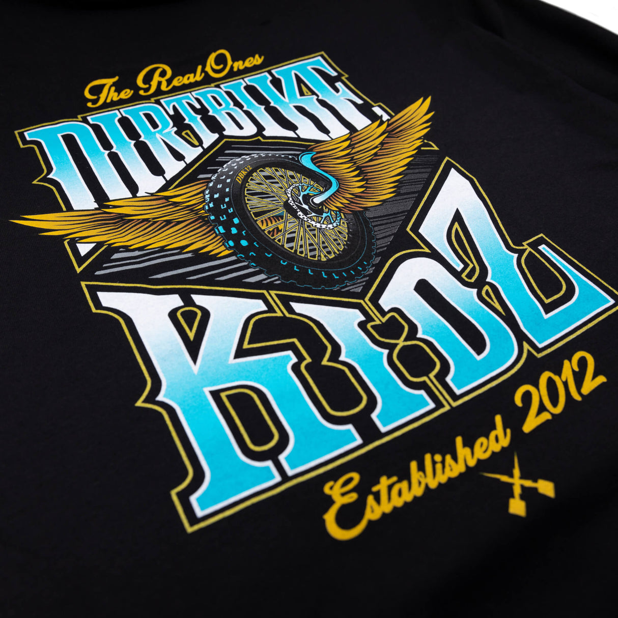 Black tee close-up: 'Dirtbike Kidz' winged wheel graphic