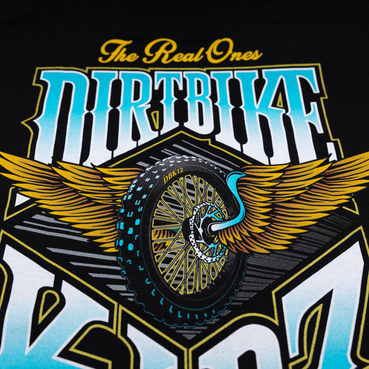 Graphic tee close-up: 'Dirtbike Kidz' logo with winged wheel