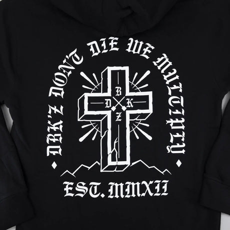 Black hoodie back close-up with large white cross emblem and curved text.