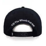 Black snapback cap back view with white text on the inner brim and strap holes.