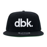 Black snapback cap with large white dbk logo on front panel