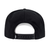 Black snapback hat back view with adjustable strap and d i c k fabric panel detail