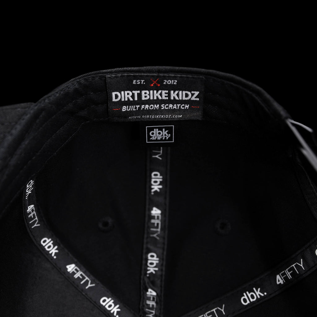 Black snapback hat interior label with Dirt Bike Kidz branding tape.