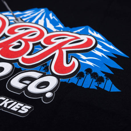 Black tee close-up of DBR Moto Co logo with blue mountain background