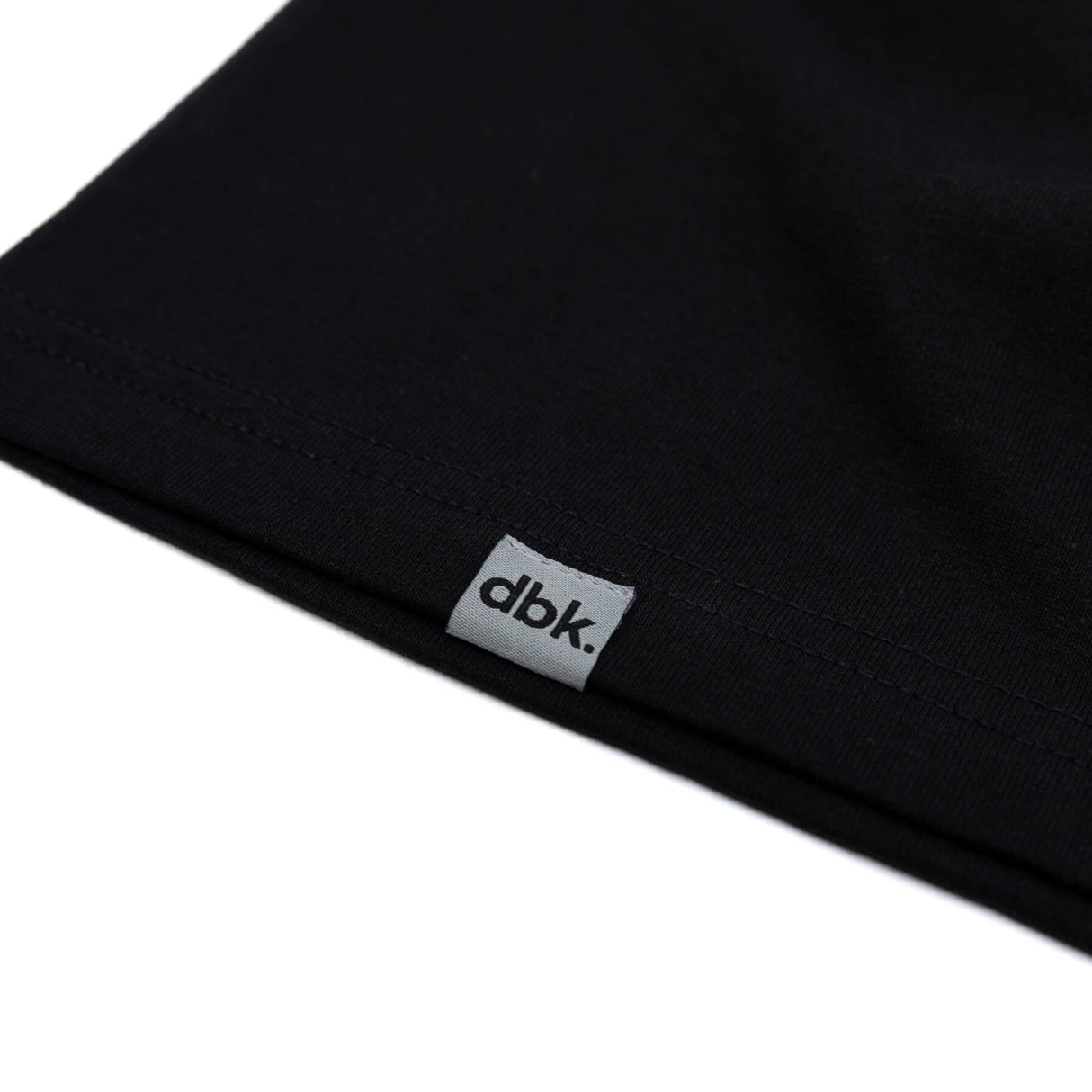 Black tank top hem with dbk label tag on side.