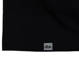 Black tank top hem with dbk label tag centered.