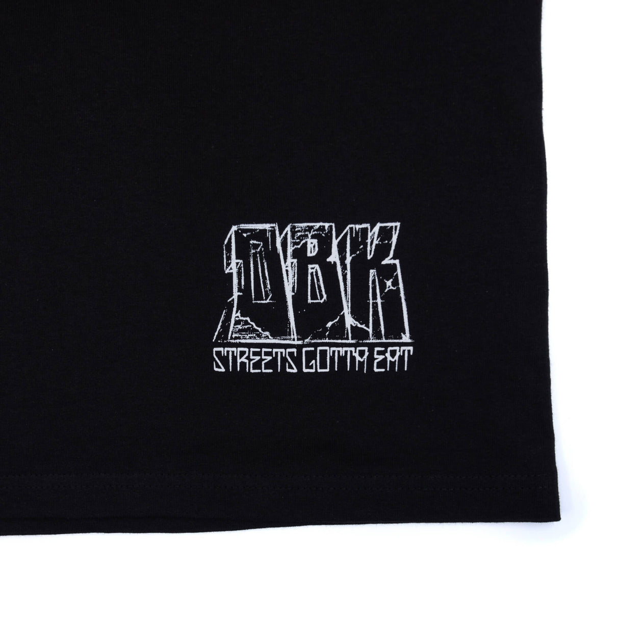 Black T-shirt close-up of white logo text print near hem