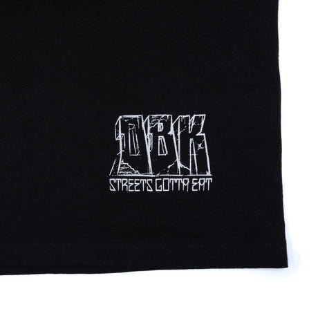 Black T-shirt close-up of white logo text print near hem