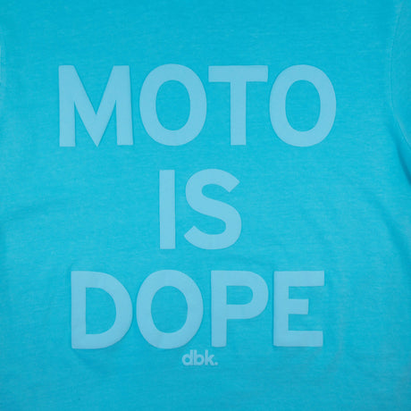 Women’s graphic T-shirt in teal with centered white “Moto is Dope” text print and dbk. mark.