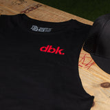 Black tank top chest close-up with red dbk. logo and crew neckline