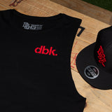 Black tank top with red dbk. logo and neckline label, plus nearby black cap