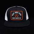 Black and white mesh trucker hat with orange logo patch front.