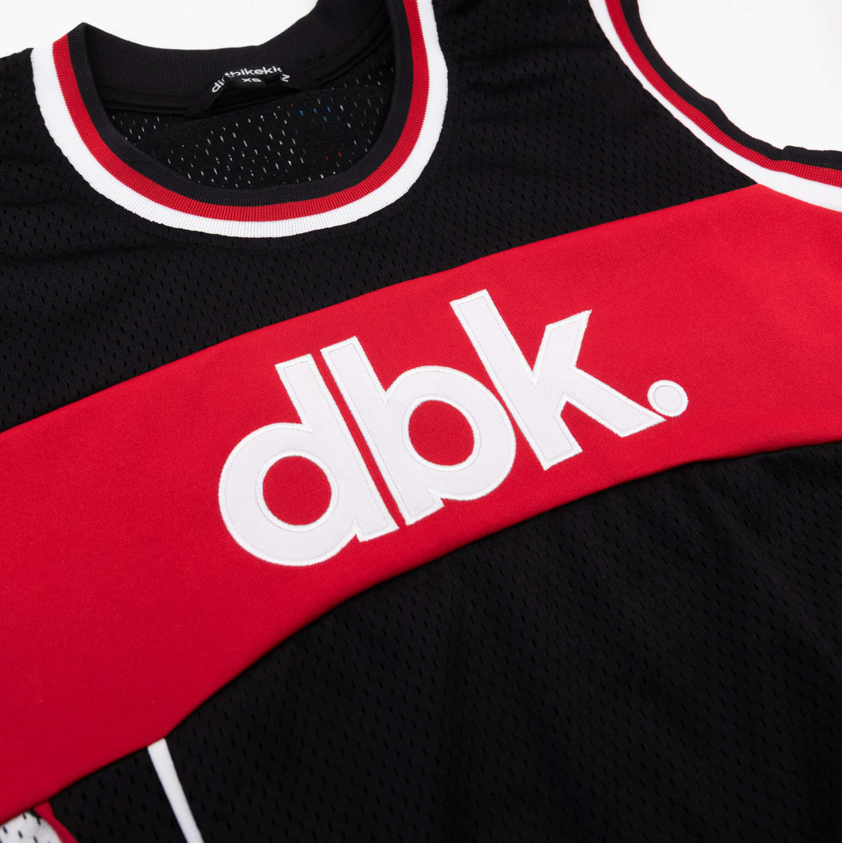 Red and black jersey tank chest band with raised dbk logo in white.