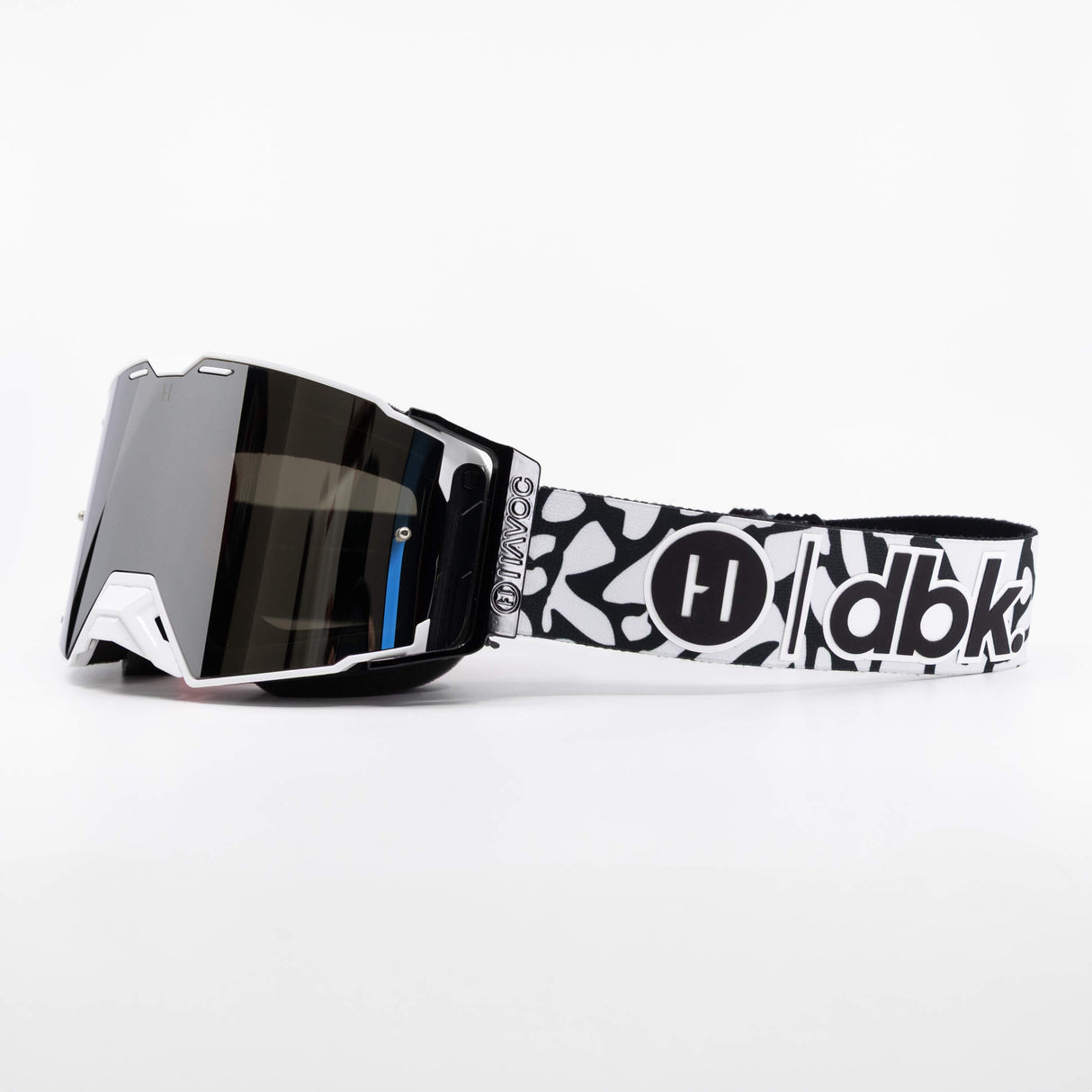 Helios goggle side view with white frame, dark lens, and black-and-white graphic band