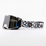 Helios goggle side view with white frame, dark lens, and black-and-white graphic band