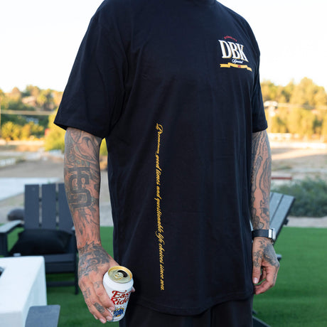 Black graphic T-shirt from behind with small DBK logo and vertical yellow side text